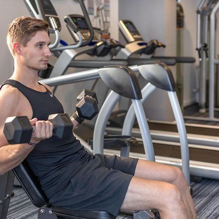 Meriton Suites North Ryde Sídney Exterior foto A man using a dumbbell to exercise